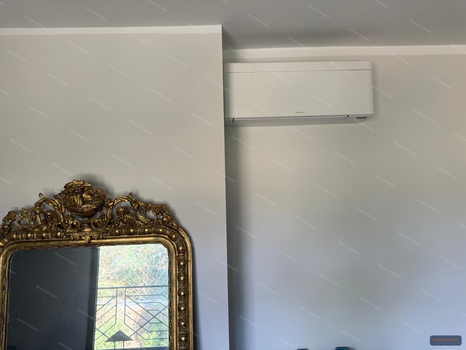 Climatiseur mural Daikin Stylish blanc installé en hauteur dans un salon avec grand miroir doré à Gragnague